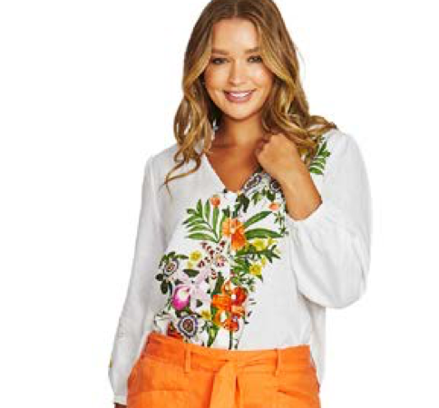 Model wearing a white long-sleeve Tigerlilly top with a colourful floral print and orange pants